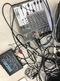 a mixer with a lot of wires and cables on the floor