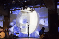 a group of people on stage with a large projection screen