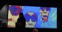 an image of a person standing in front of a large screen