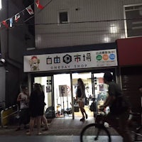 a group of people walking past a shop at night